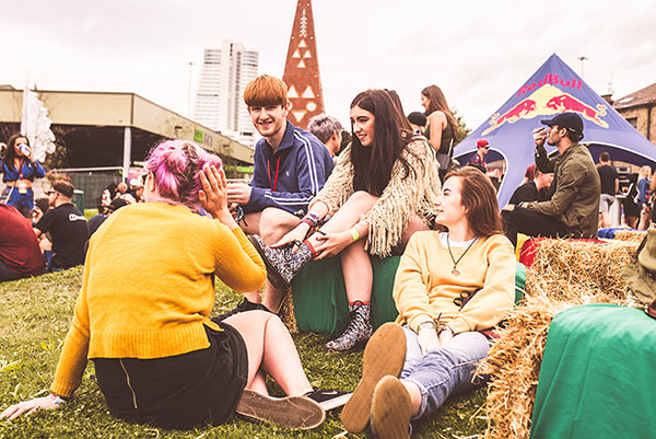 Group of friends gathered round talking at a festival